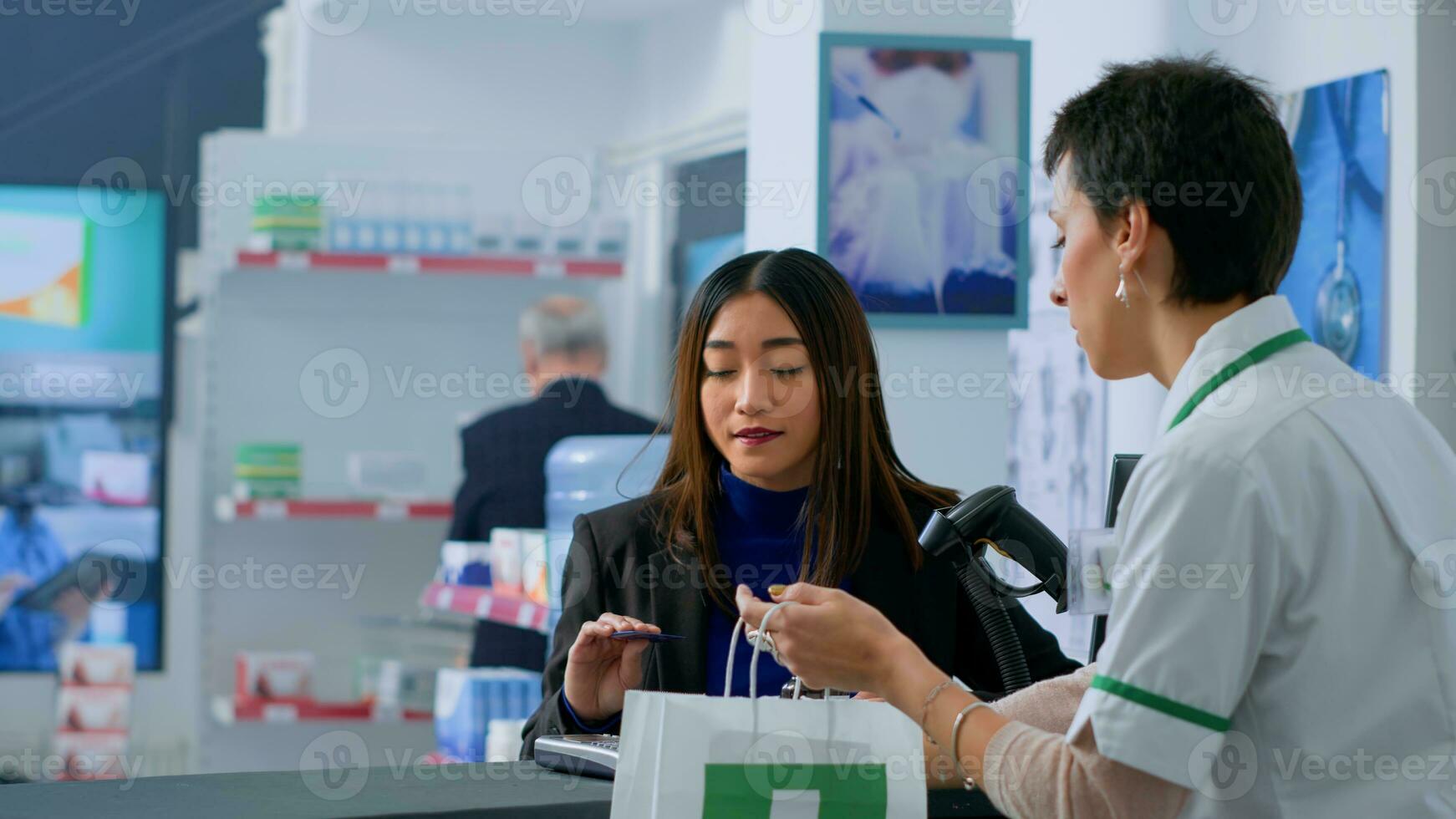 cliente dentro dispensário às Verificação de saída contador usando crédito cartão para Comprar farmacêutico medicamento. amigáveis cliente fazendo sem contato compra dentro farmacia depois de achando necessário dor de cabeça atenuação pílulas foto