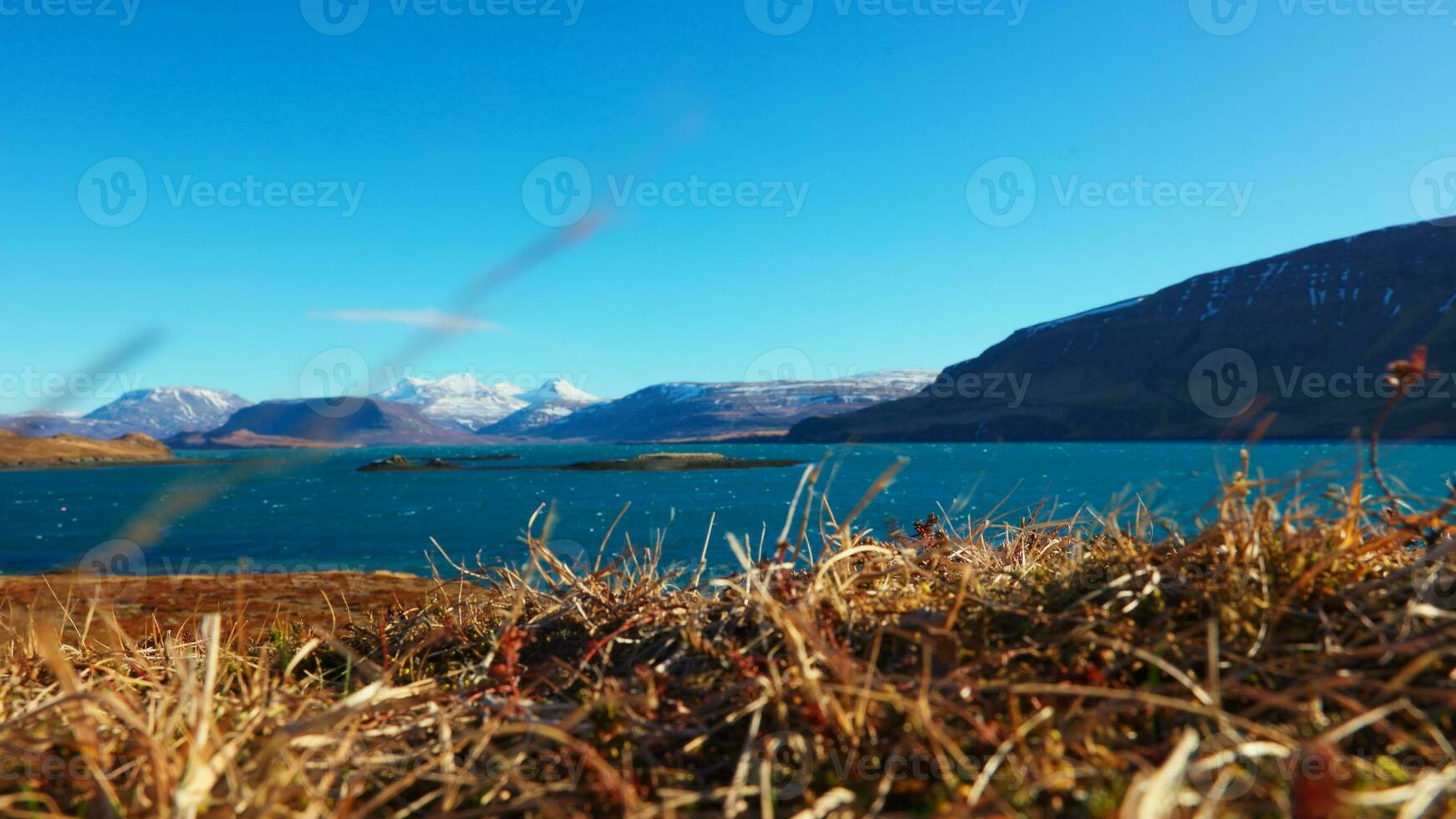 colorida islandês panorama com lago cercado de Nevado montanhas e colinas, lindo congeladas terra. fantástico nórdico natureza formando paraíso cenário com ampla Campos e água. tripé tomada. foto