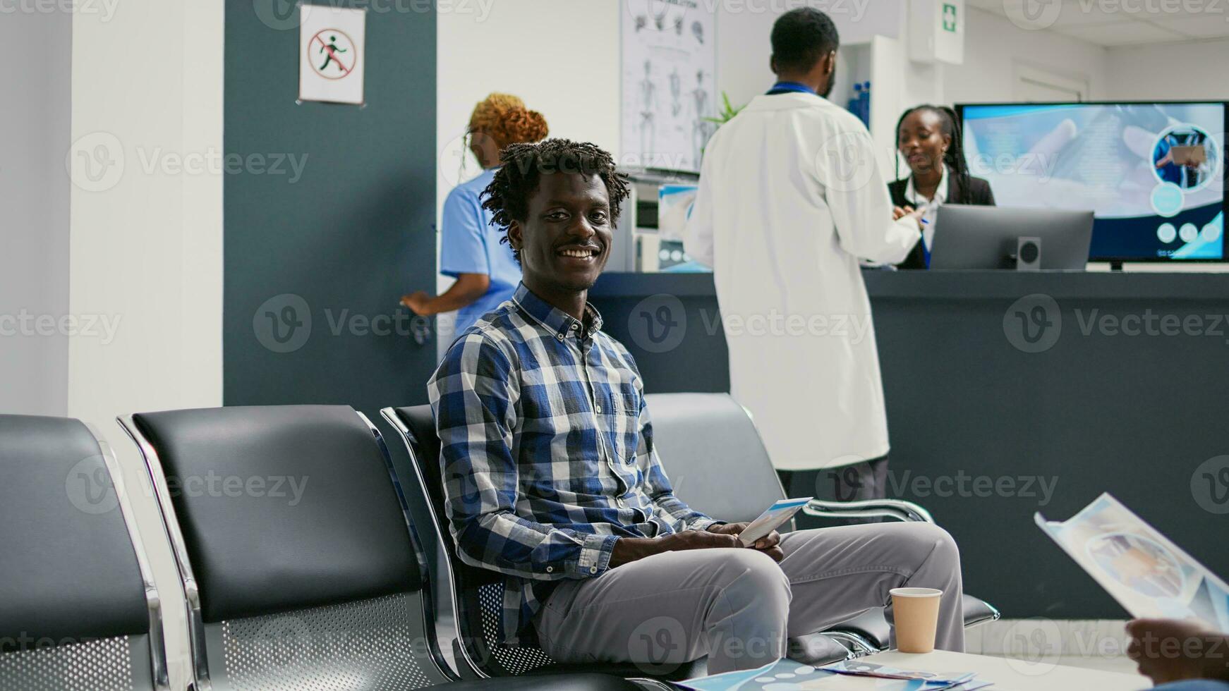 masculino paciente esperando para comparecer consulta com doutor, sentado dentro hospital recepção. jovem adulto dentro esperando área tendo checar exame compromisso com especialista para cura doença às saúde Centro. foto