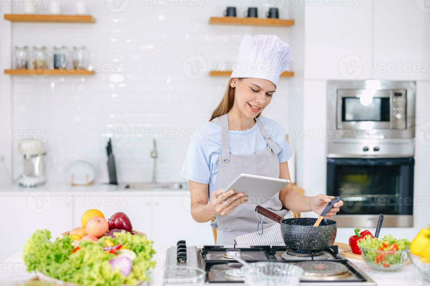feliz mulher apreciar cozinhando Comida às casa cozinha Aprendendo saudável legumes cozinhar assistindo conectados classe Internet vídeo dentro tábua foto