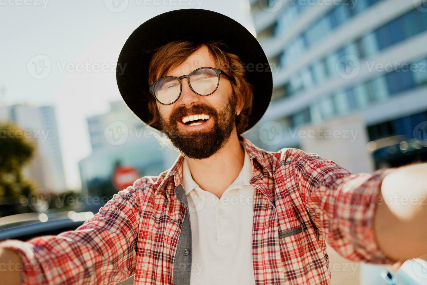 engraçado homem com barba fazer auto retrato de Câmera enquanto ele viajando dentro grande moderno cidade dentro Ásia. foto