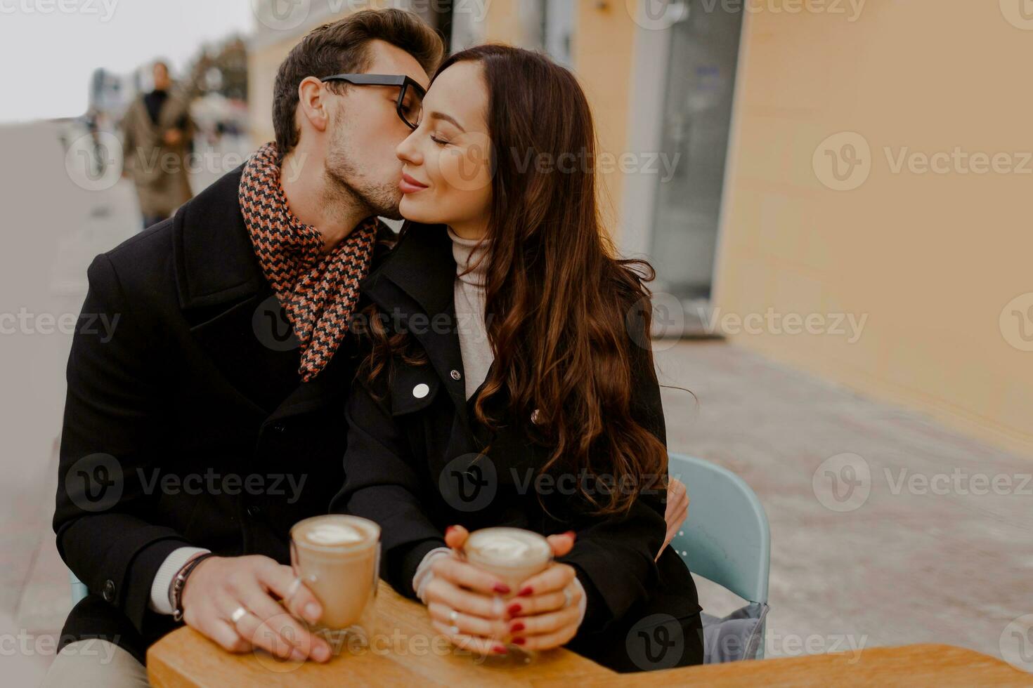 bonito homem e dele elegante namorada abraçando e desfrutando quente bebida dentro cafeteria . foto