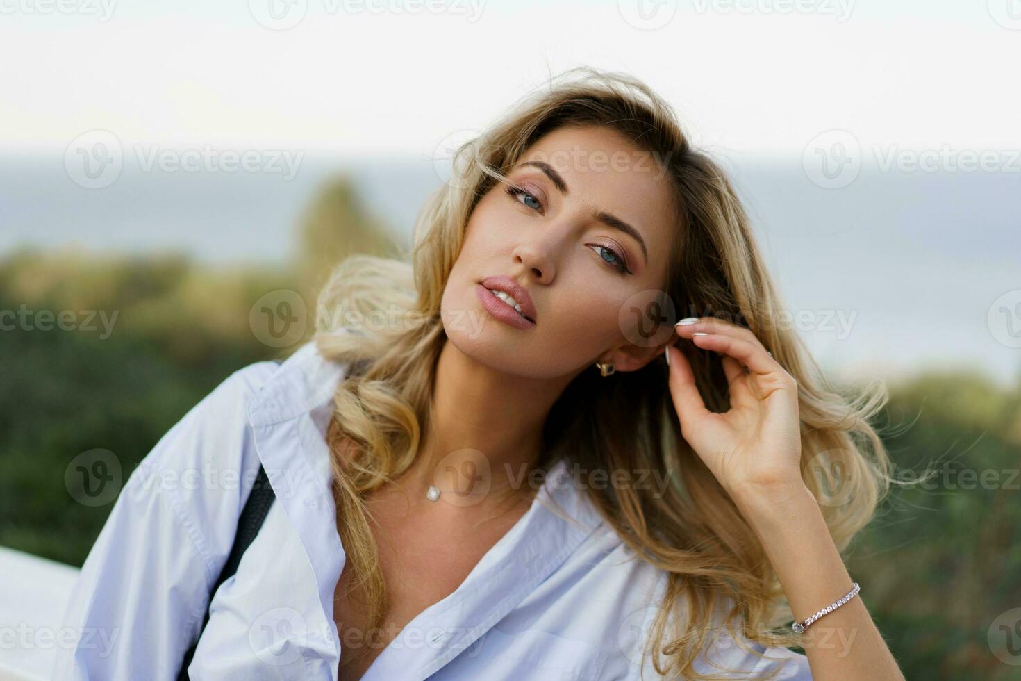 retrato do lindo encantador loiro mulher com perfeito pele e ondulado cabelos posando ao ar livre durante período de férias dentro Europa. foto