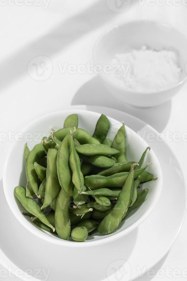 lanche de feijão edamame orgânico em uma tigela na mesa com sal marinho foto