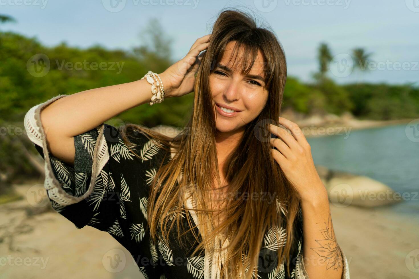 bonita mulher dentro boêmio vestir posando em tropical de praia. viajando e período de férias humor. foto