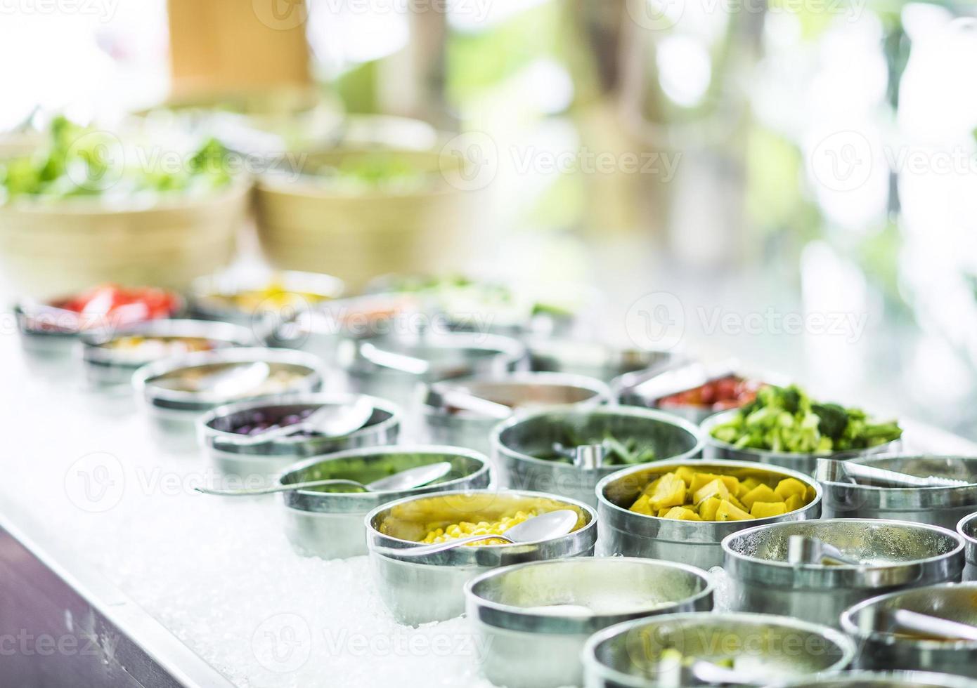 tigelas de pimentas vermelhas orgânicas frescas e vegetais misturados em uma moderna vitrine de bufê de saladas foto