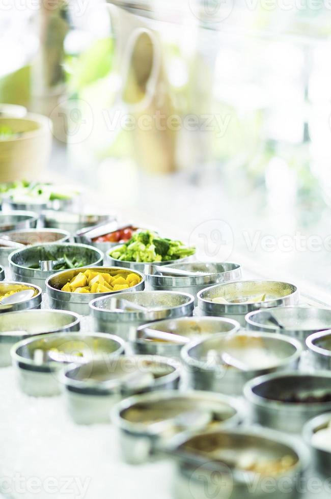 tigelas de pimentas vermelhas orgânicas frescas e vegetais misturados em uma moderna vitrine de bufê de saladas foto