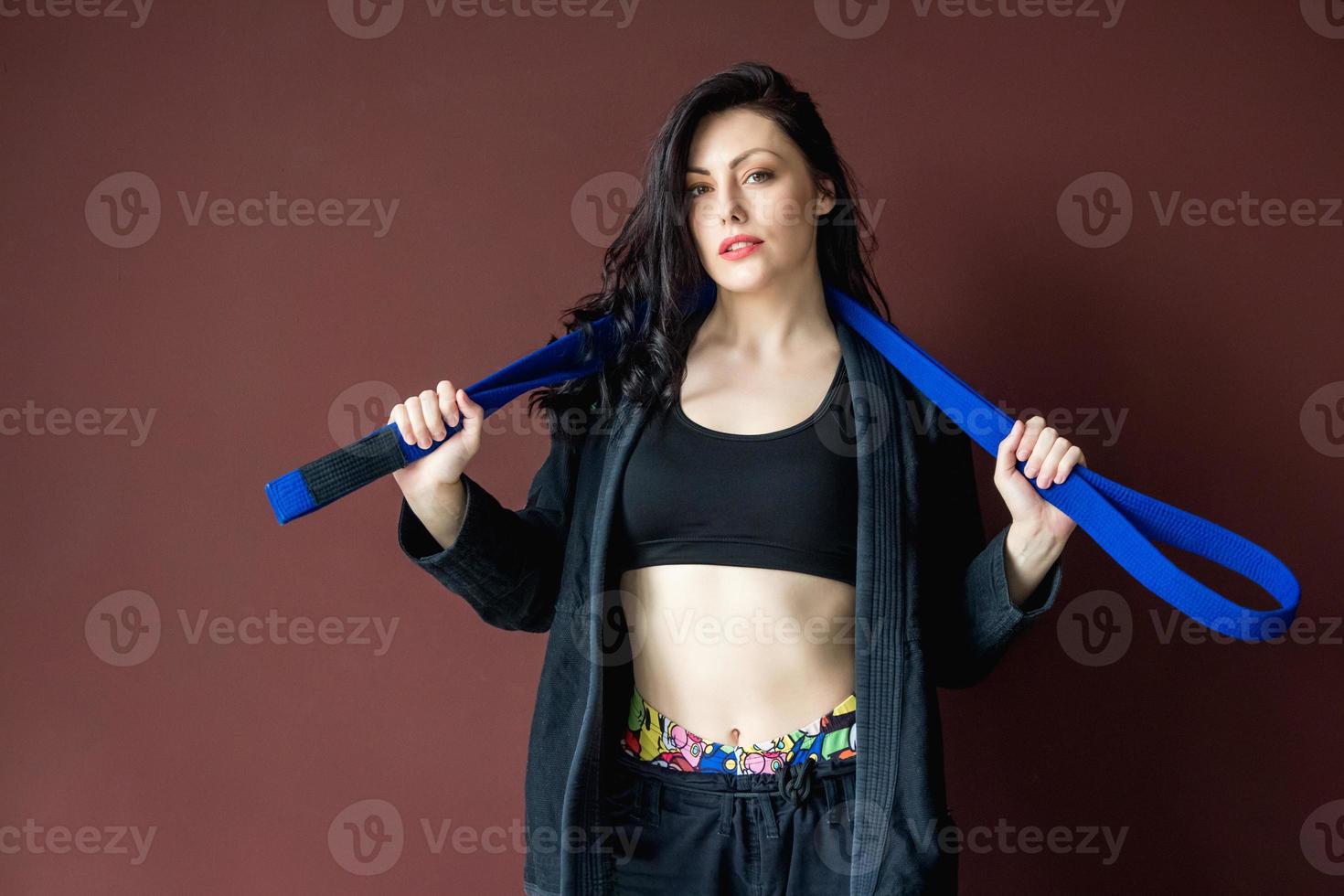 linda mulher atlética com faixa azul no fundo da parede foto