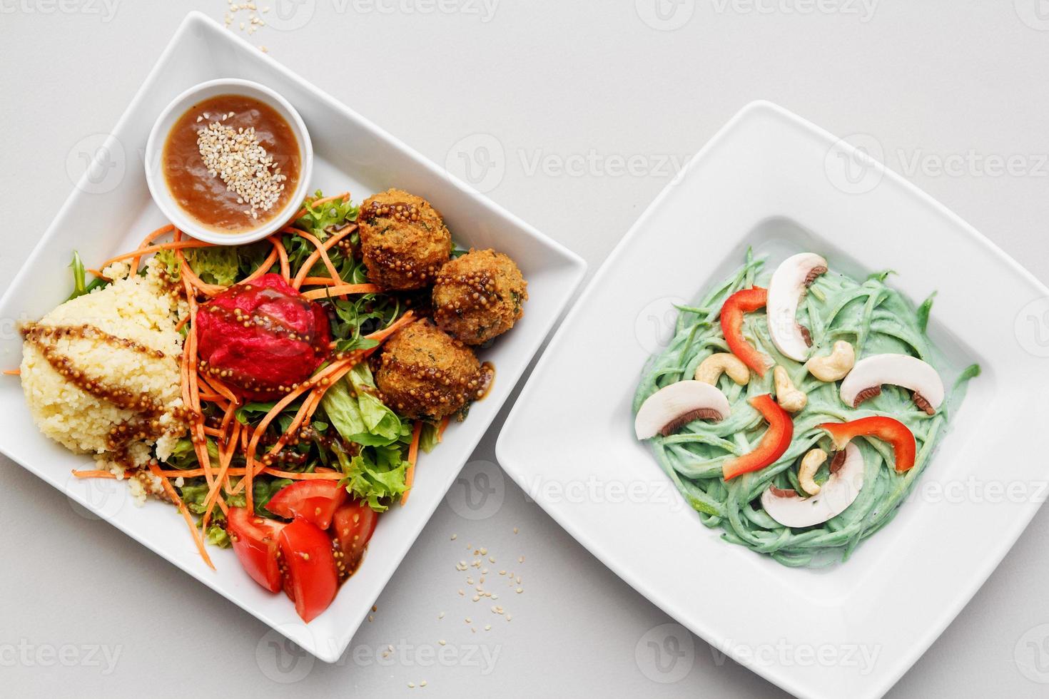 pratos brancos com pasta de legumes e falafels em um fundo branco foto