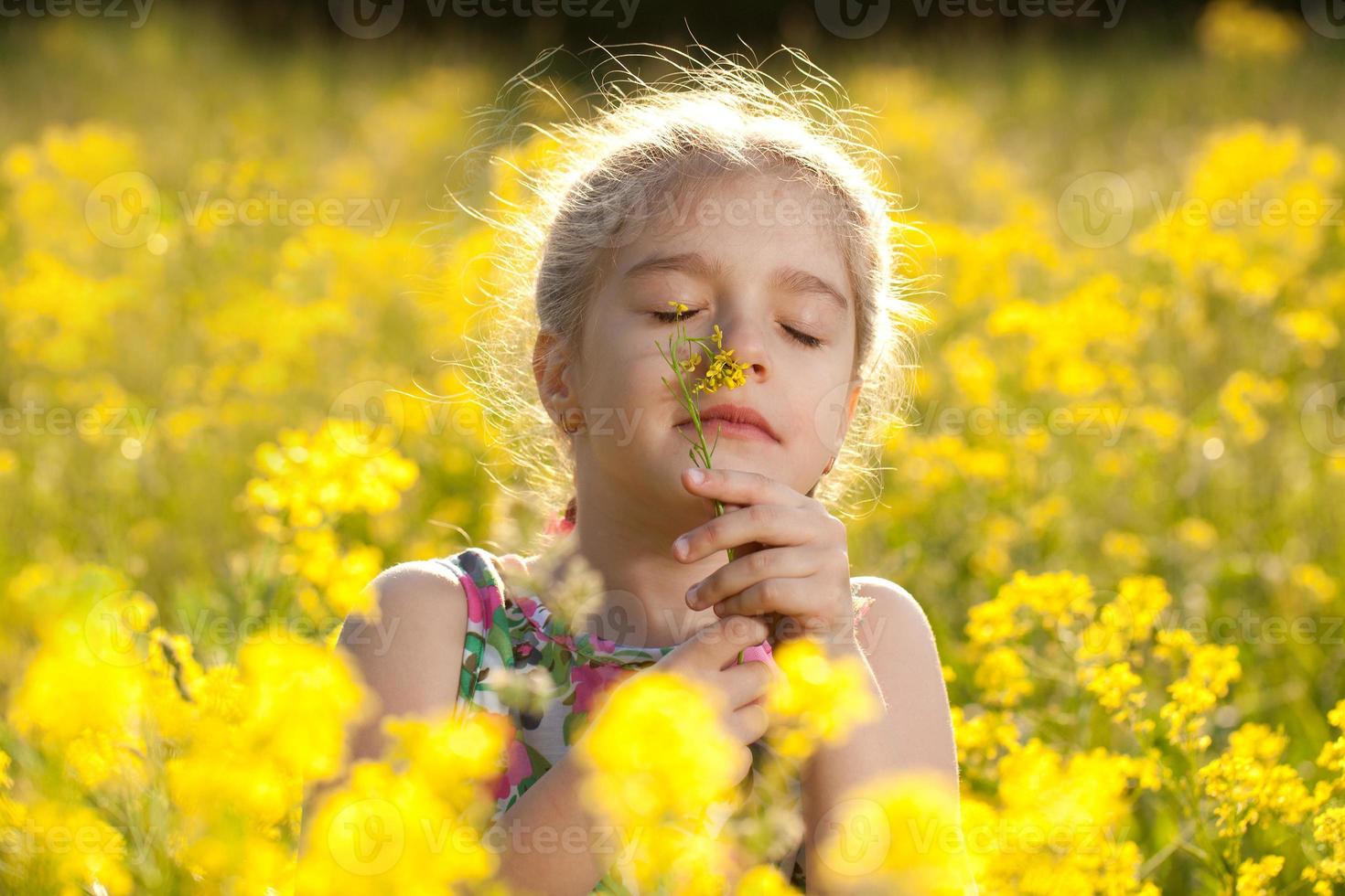 menina gosta do cheiro de flores foto