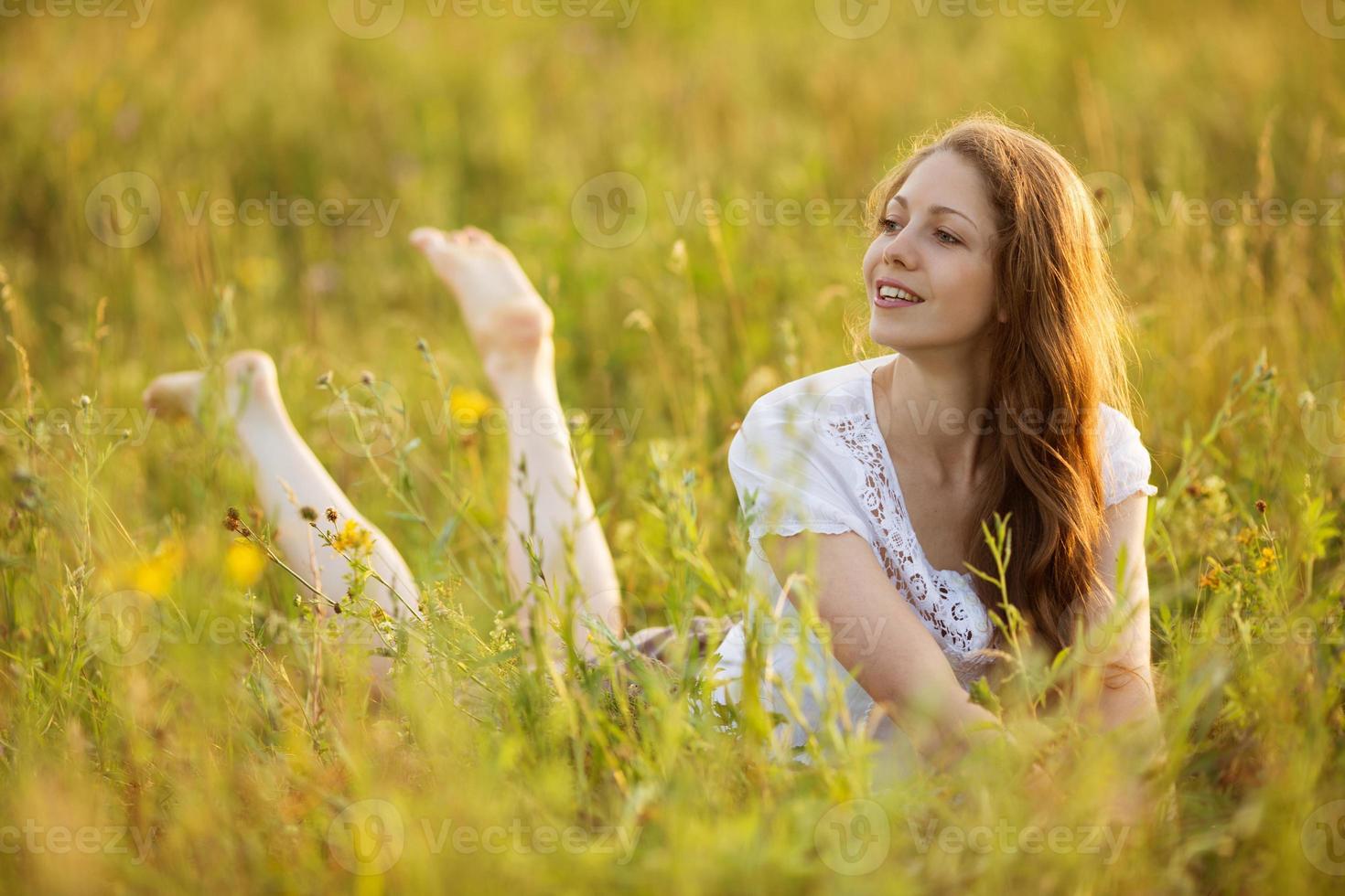 jovem mulher feliz parece fora da grama foto