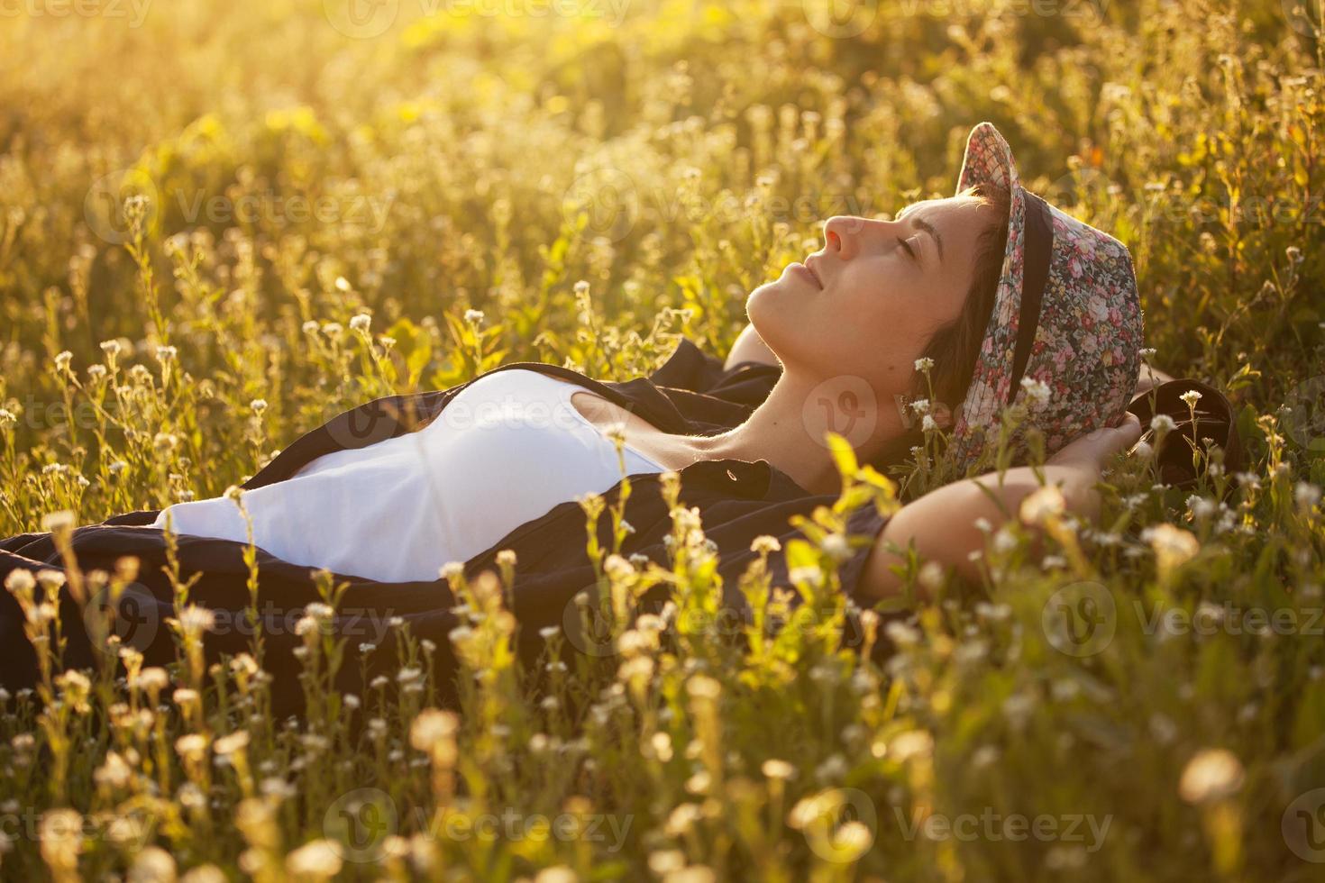 a garota com um chapéu dremet entre flores silvestres foto