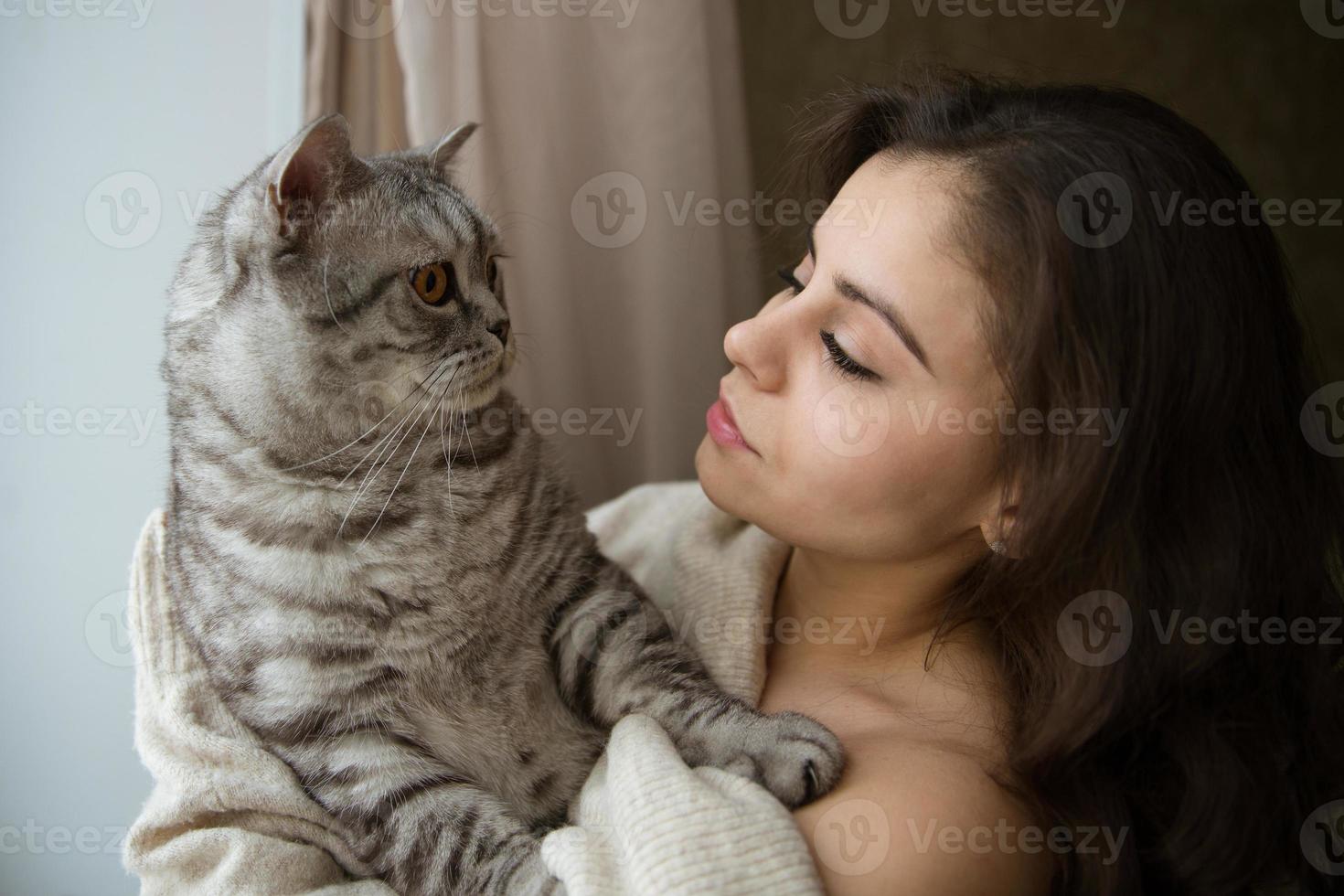 garota segurando um grande gato cinza foto