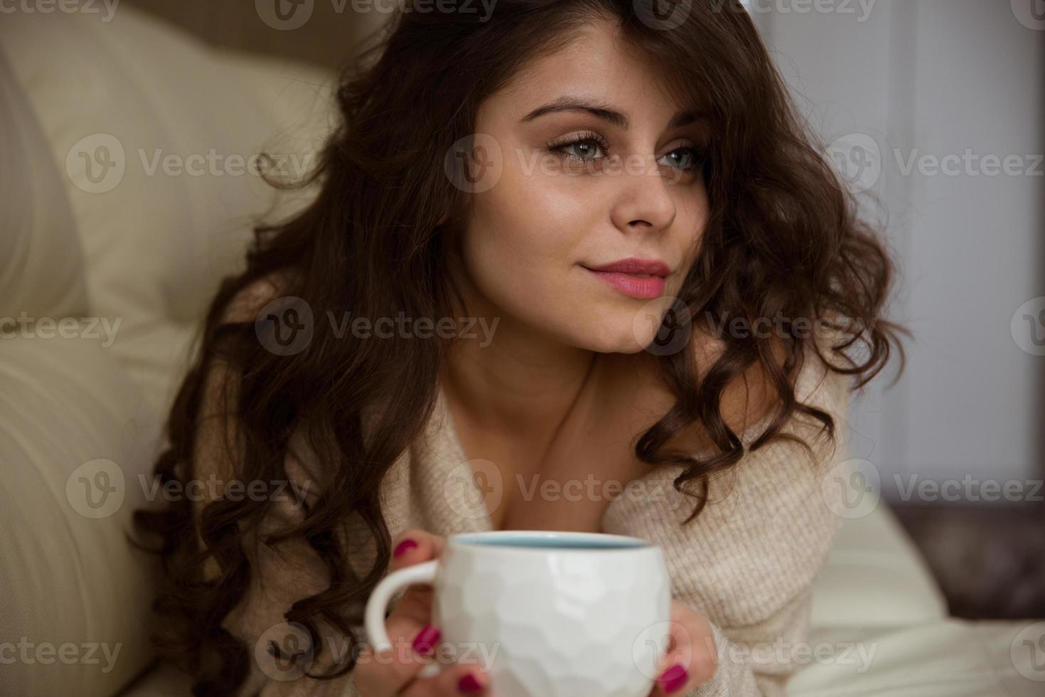 linda mulher deitada com uma xícara de café foto
