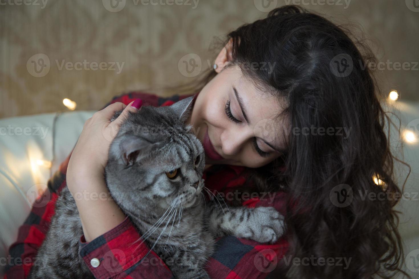 jovem mulher com um grande gato cinza foto