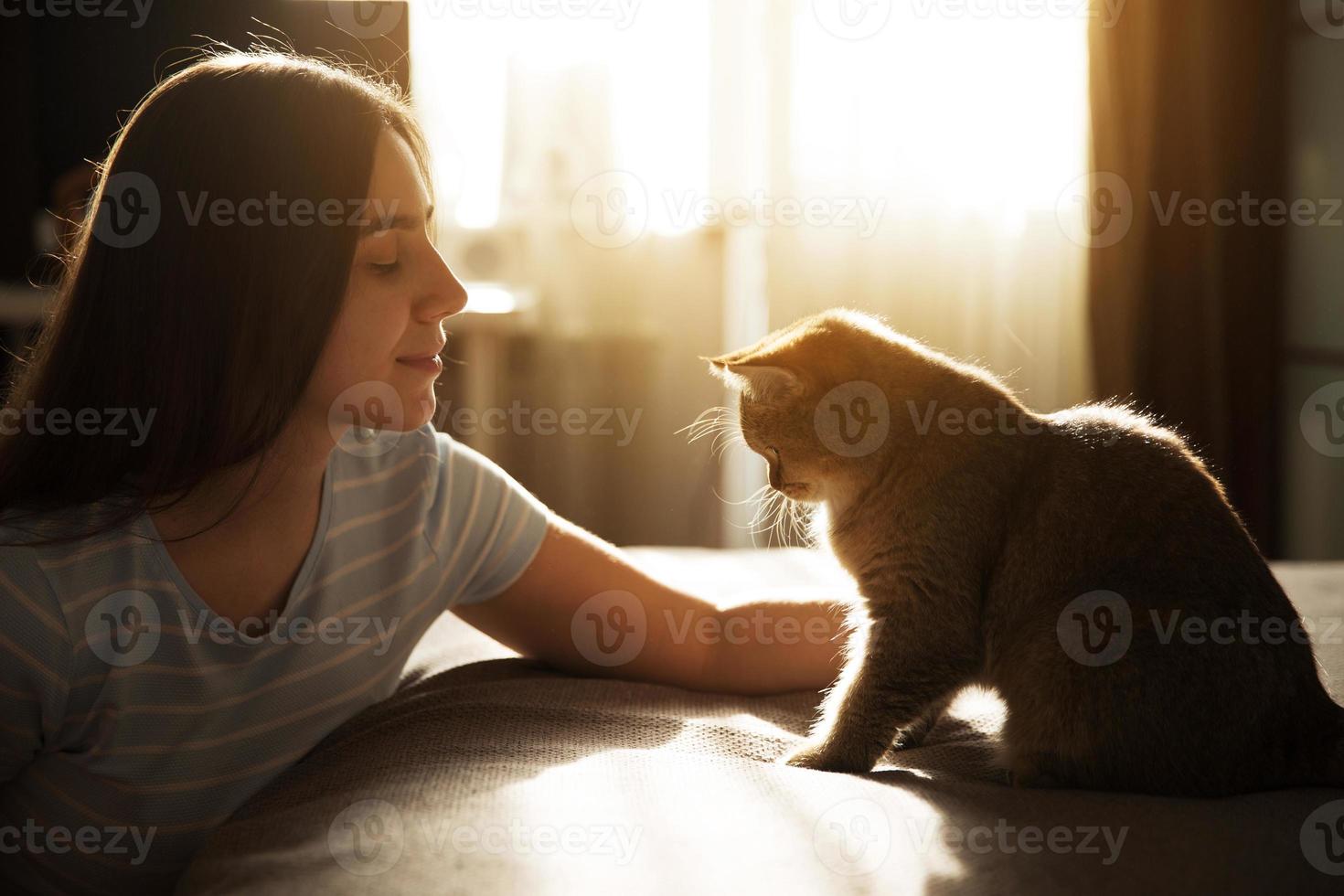 garota acariciando seu amado gato vermelho foto