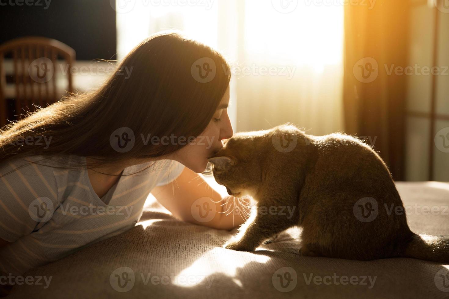 mulher beija seu amado gato vermelho foto