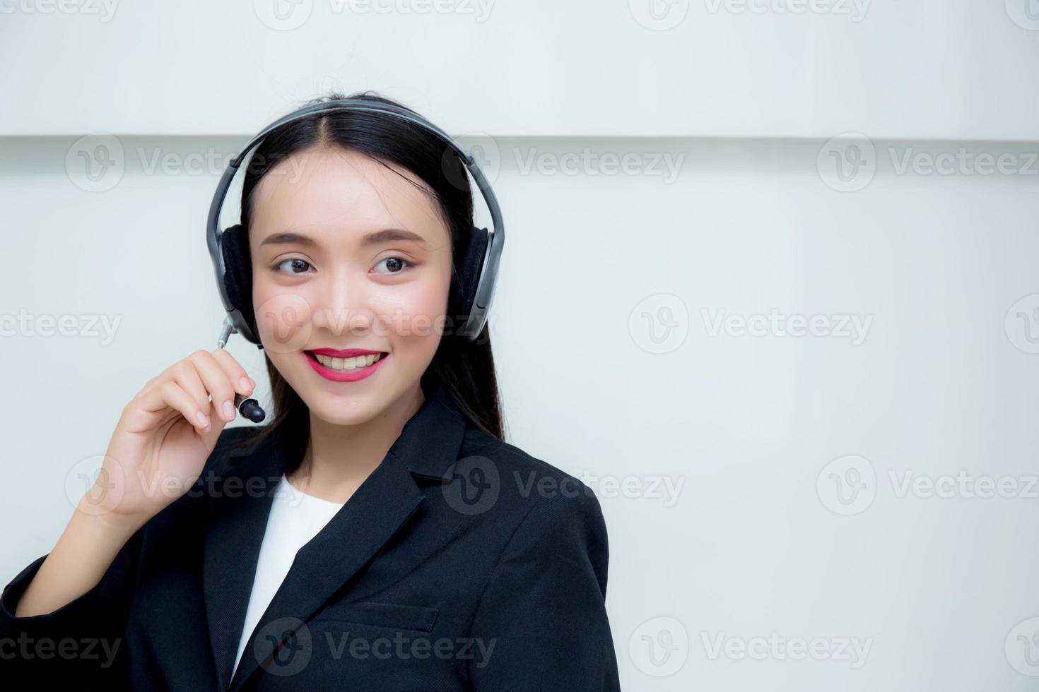 jovem mulher asiática sorrindo atendimento ao cliente, falando no fone de ouvido. foto