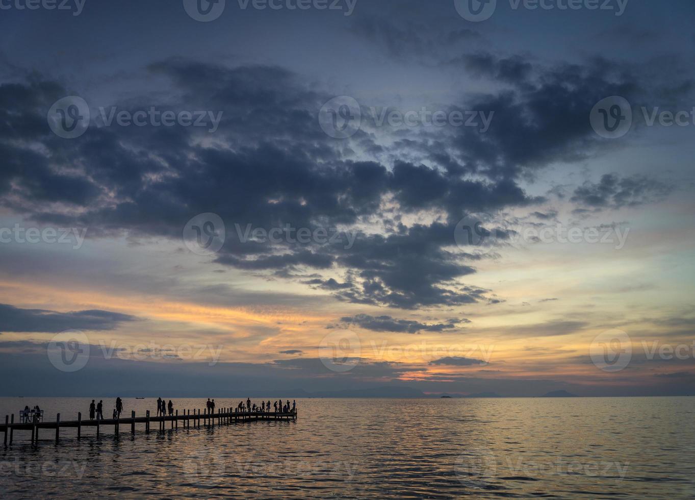 turistas veem o pôr do sol no cais na cidade de Kep, na costa do Camboja foto