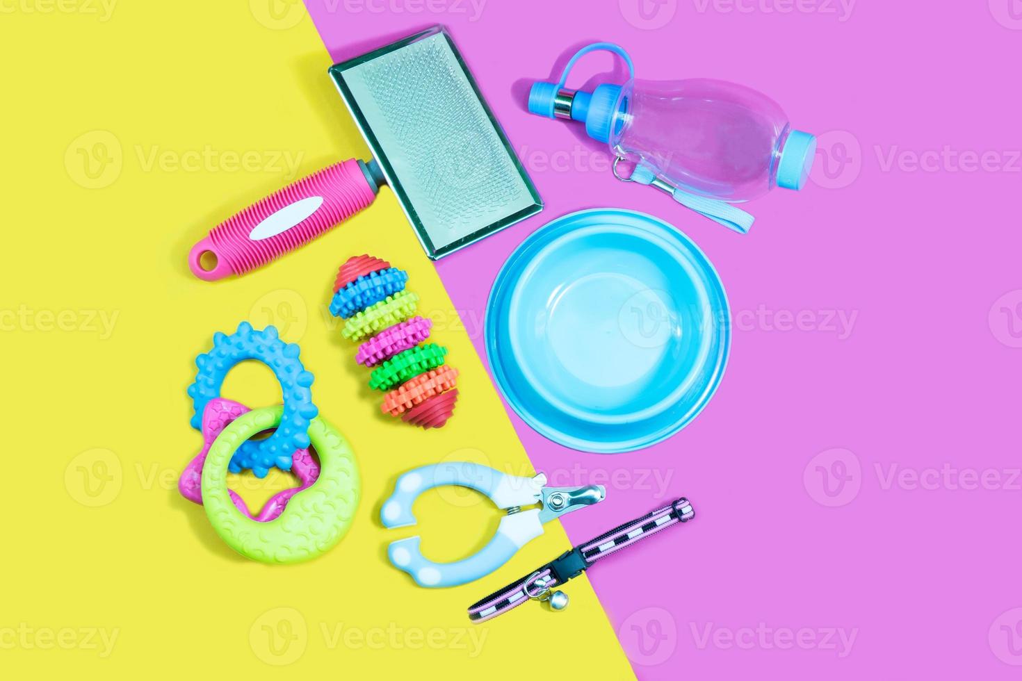 conceito de acessórios para animais de estimação - tigela, brinquedos, escova, coleiras e tesouras de unha em fundo amarelo e rosa. foto