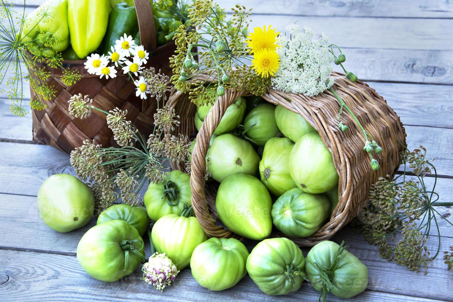 vegetais em uma cesta e um buquê de flores silvestres. foto