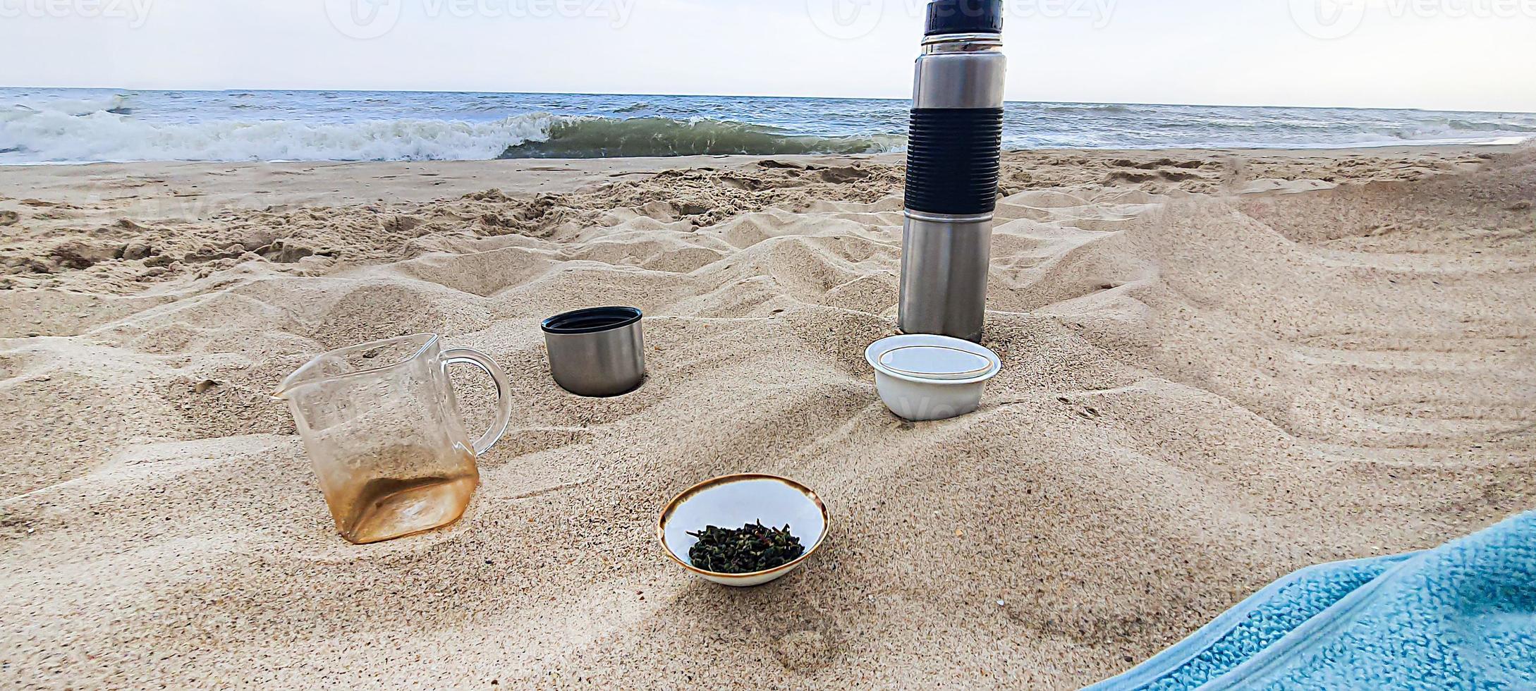 beira-mar. pratos com chá na areia. férias de verão. foto