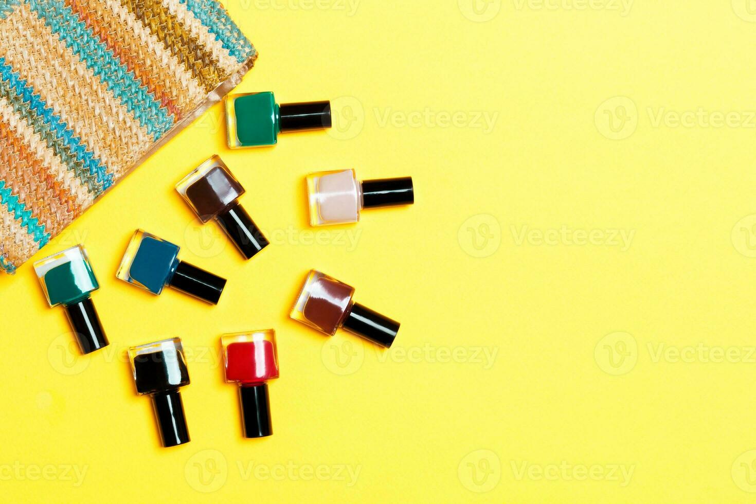 bolsa cosmética de mulher com manicure e pedicure, vernizes de gel brilhantes sobre fundo amarelo com espaço de cópia para seu projeto e texto. conceito de postura plana de trabalho de unhas foto