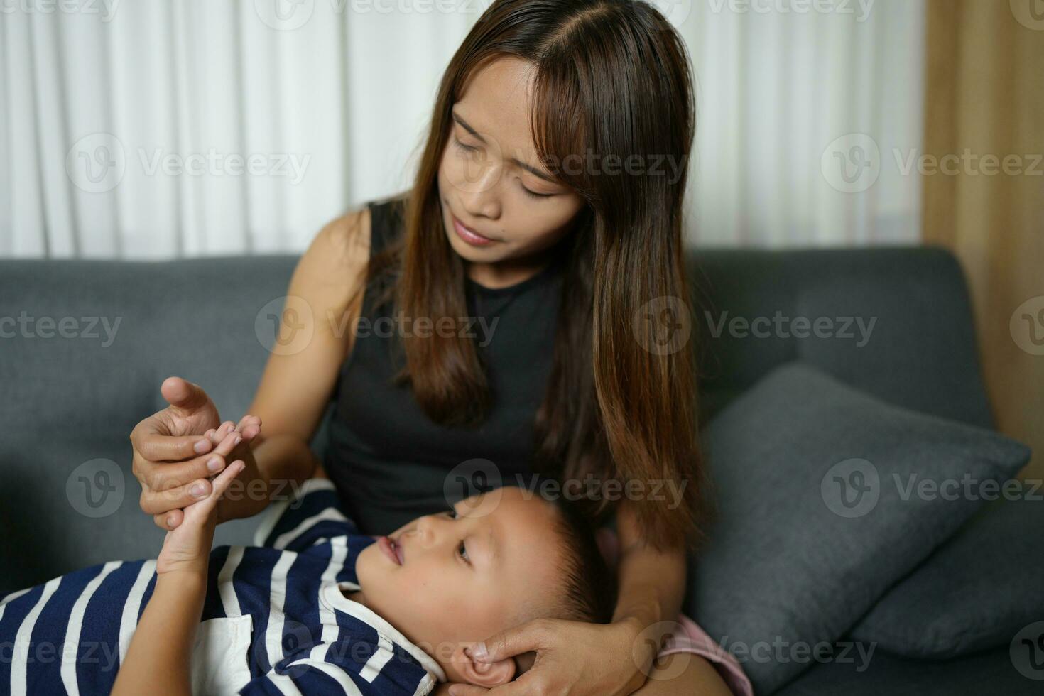 uma filho dorme em dele mãe colo dentro a casa. foto