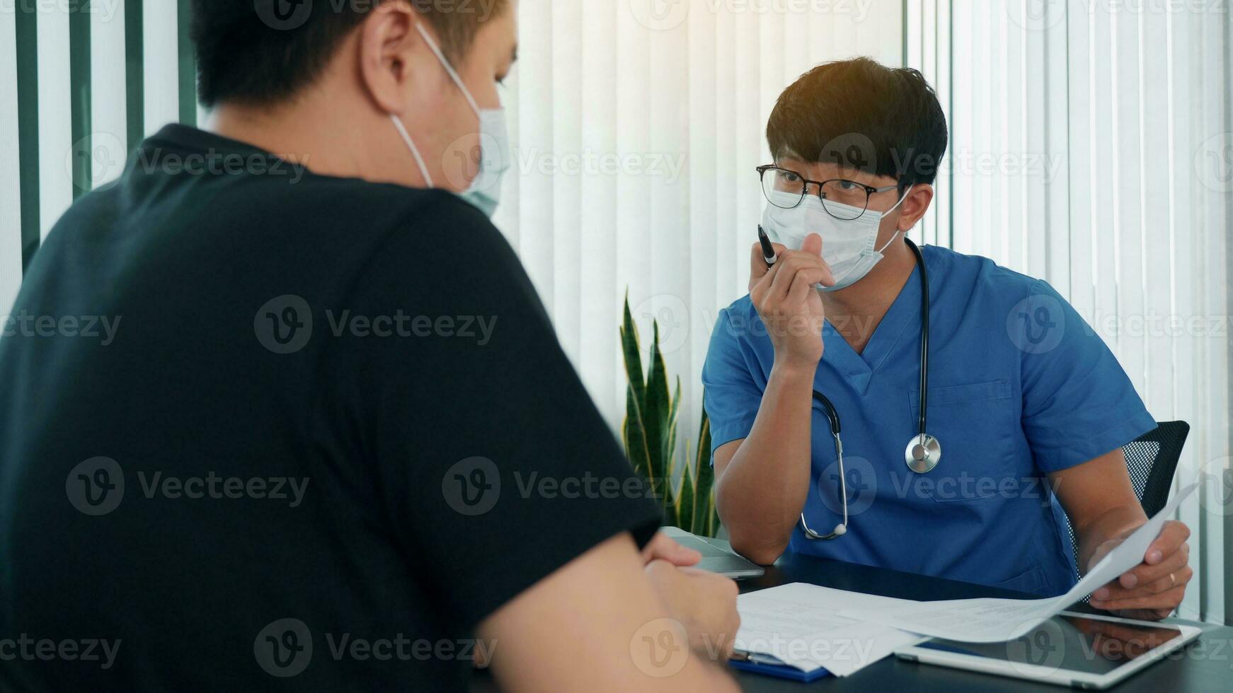 os médicos estão explicando o tratamento da doença de um paciente usando uma máscara durante a epidemia. foto