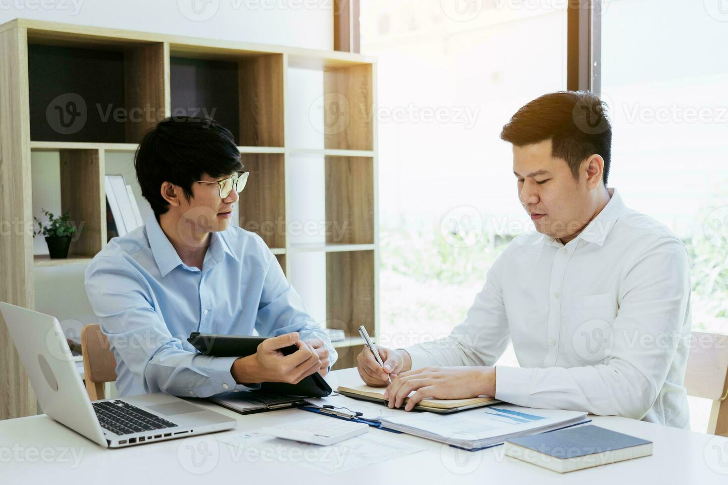 homem de negocios explicando para colegas uma gráfico do financeiro despesas figuras dentro uma tábua. foto