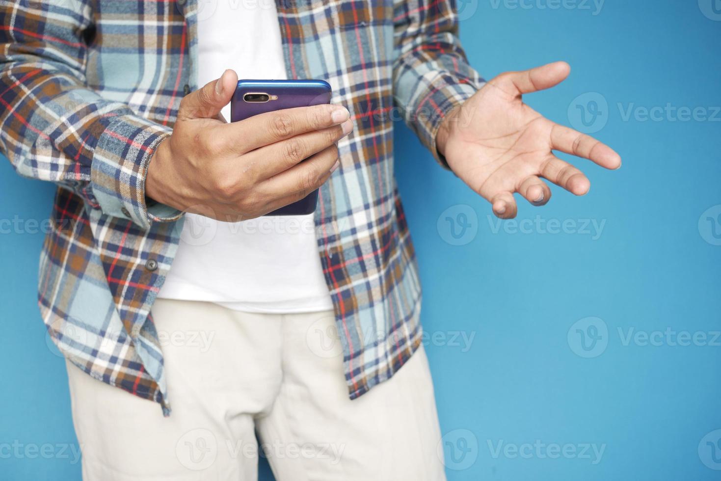 Feche a mão do jovem usando um telefone inteligente foto