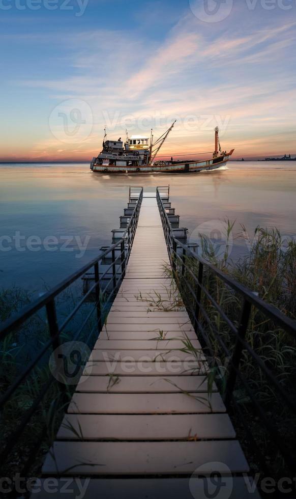 barco de pesca passando pelo cais. foto