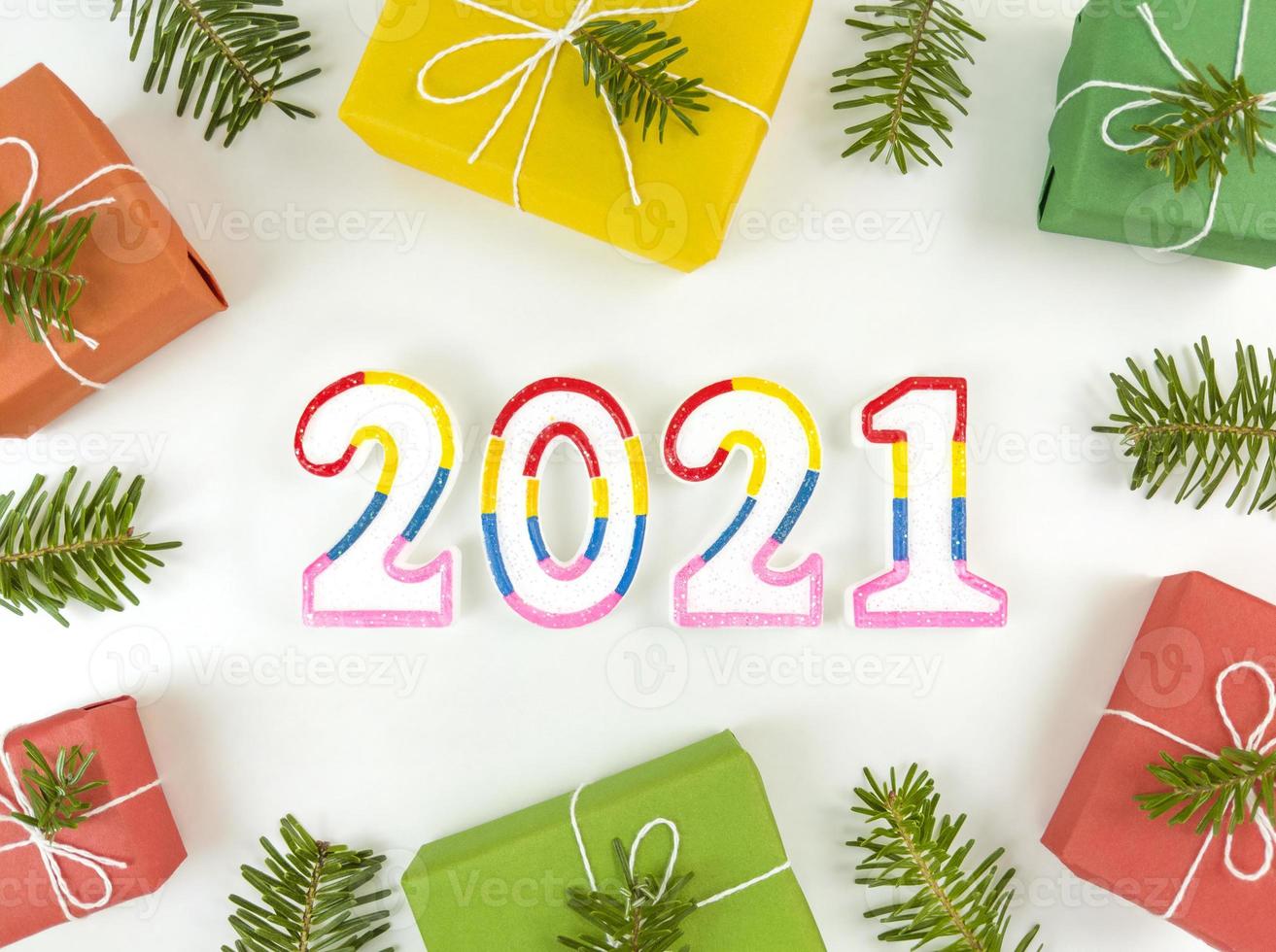 postal de férias com galhos de pinheiros, caixas de presente e bonecos de 2021 foto