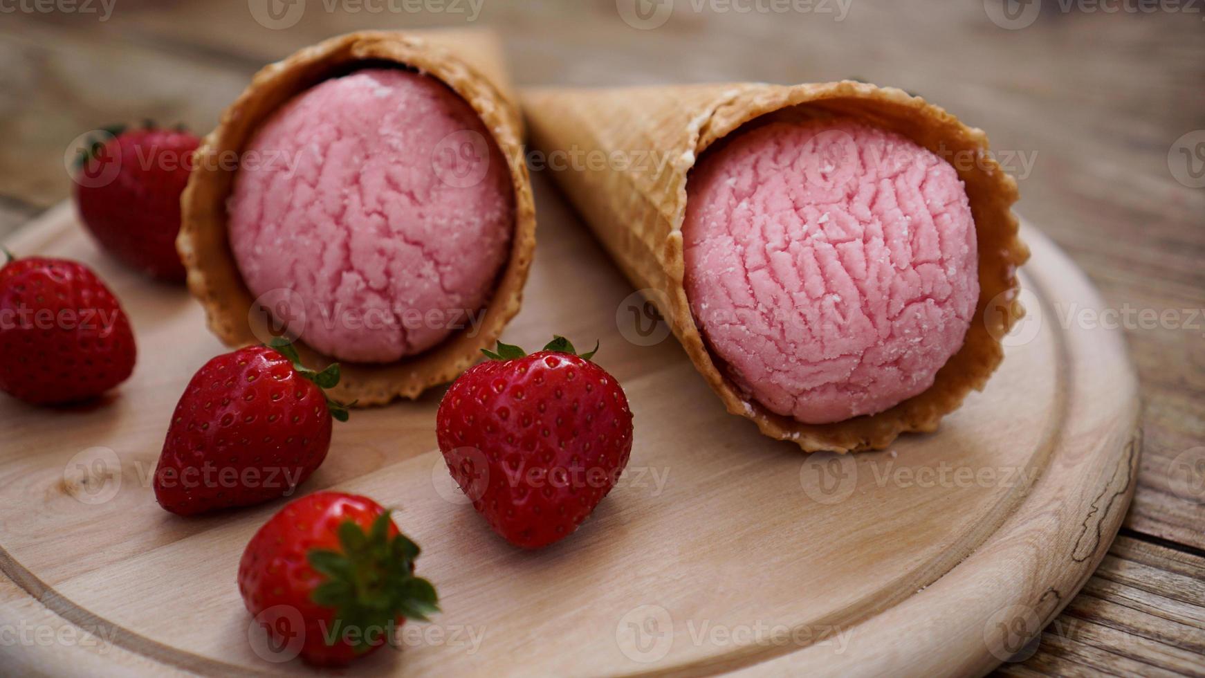 sorvete de morango em uma casquinha de waffle. frutas vermelhas e bolas de sorvete foto