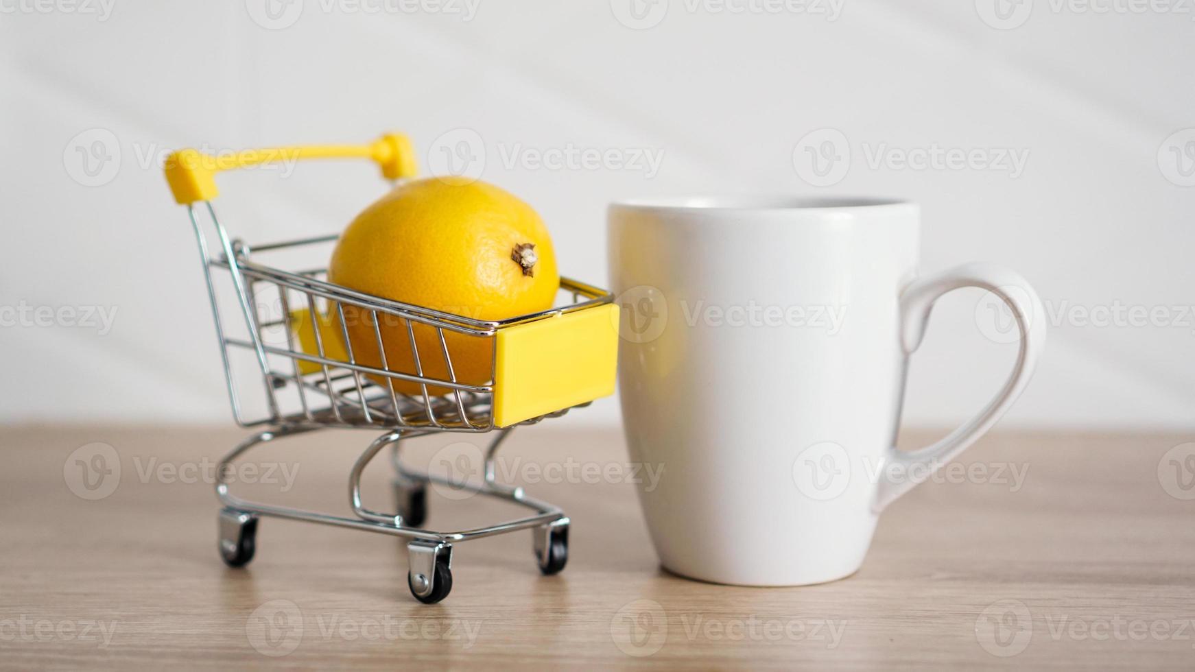 limão em um pequeno carrinho de compras na mesa da cozinha foto
