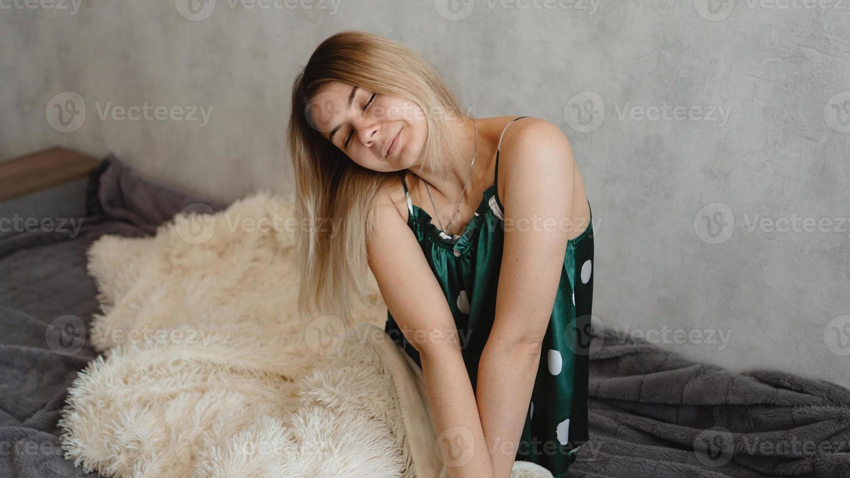 bela loira sorridente de pijama verde. conceito de bom dia foto