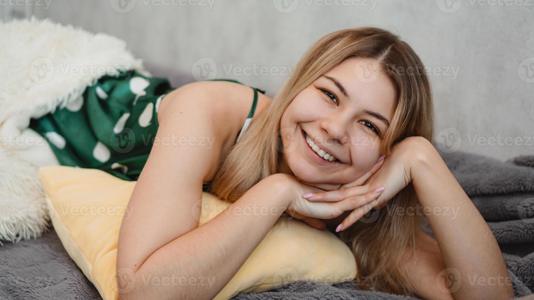 bela loira sorridente de pijama verde. conceito de bom dia foto