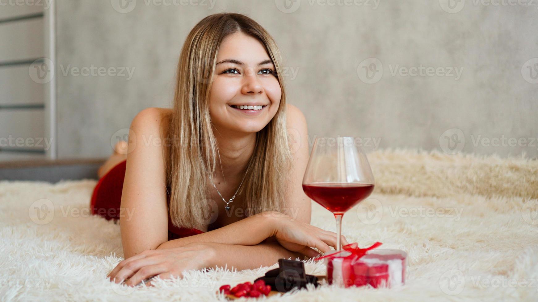 uma bela loira sorridente encontra-se na cama. dia dos namorados de manhã foto