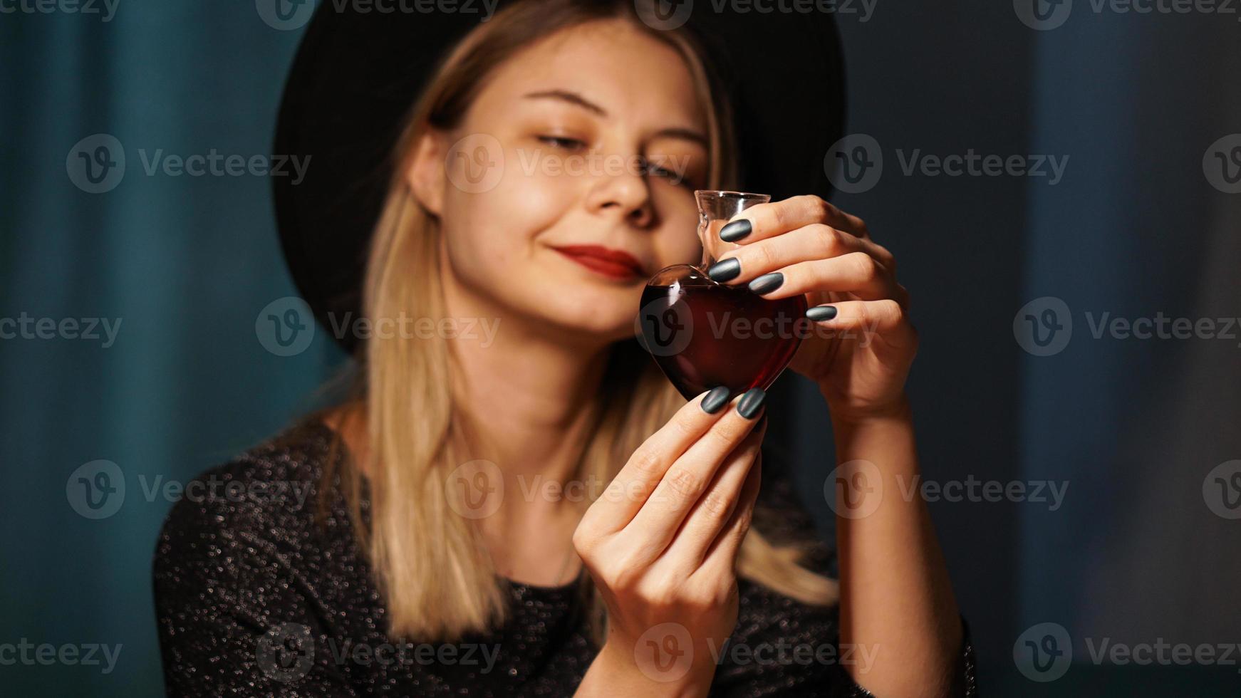 imagem recortada de mulher segurando um frasco de vidro em forma de coração com poção do amor foto