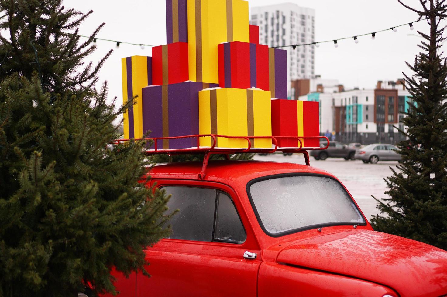 carro retro vermelho de natal com caixas de presente do lado de fora foto
