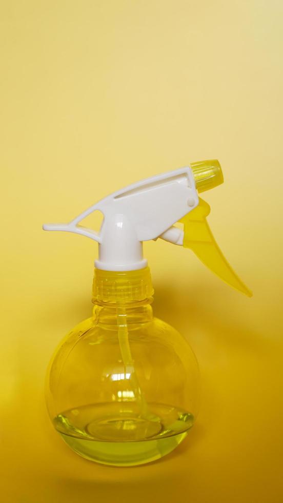 frasco de spray em fundo amarelo foto