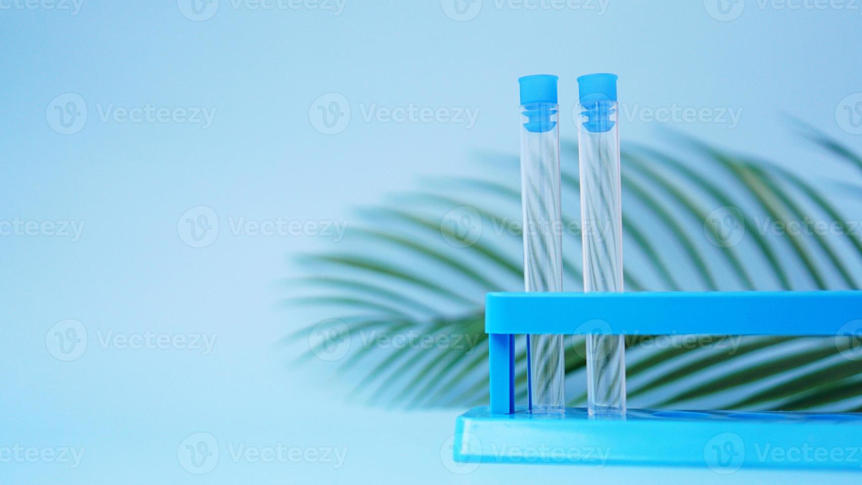tubos de ensaio em um fundo azul. folha tropical. doença tropical foto