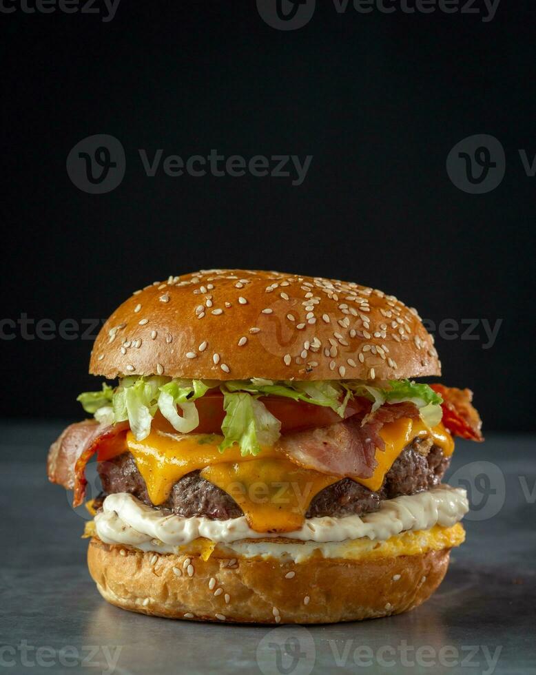 caseiro Hamburger com carne bovina, queijo e legumes em Preto fundo foto