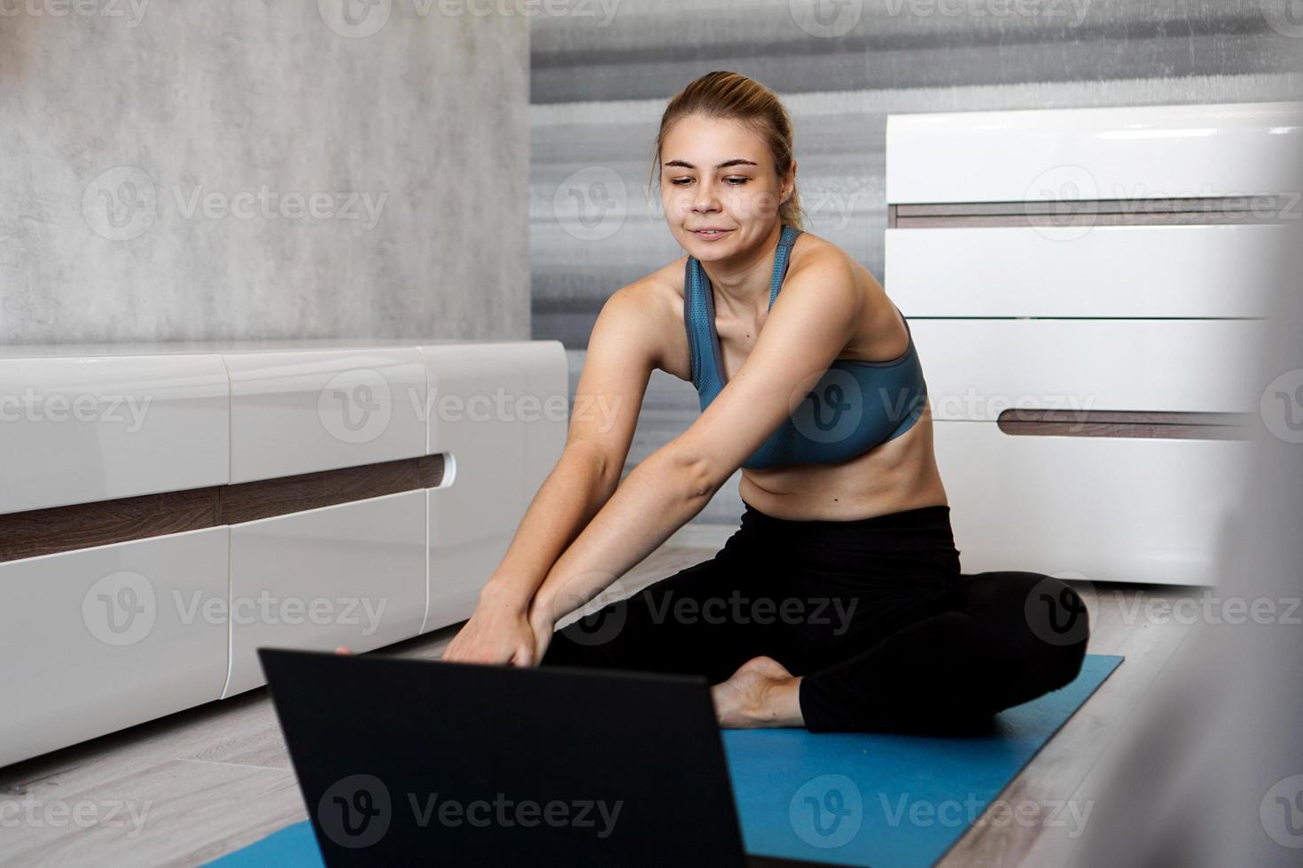 mulher em roupas esportivas assistindo vídeo online no laptop foto