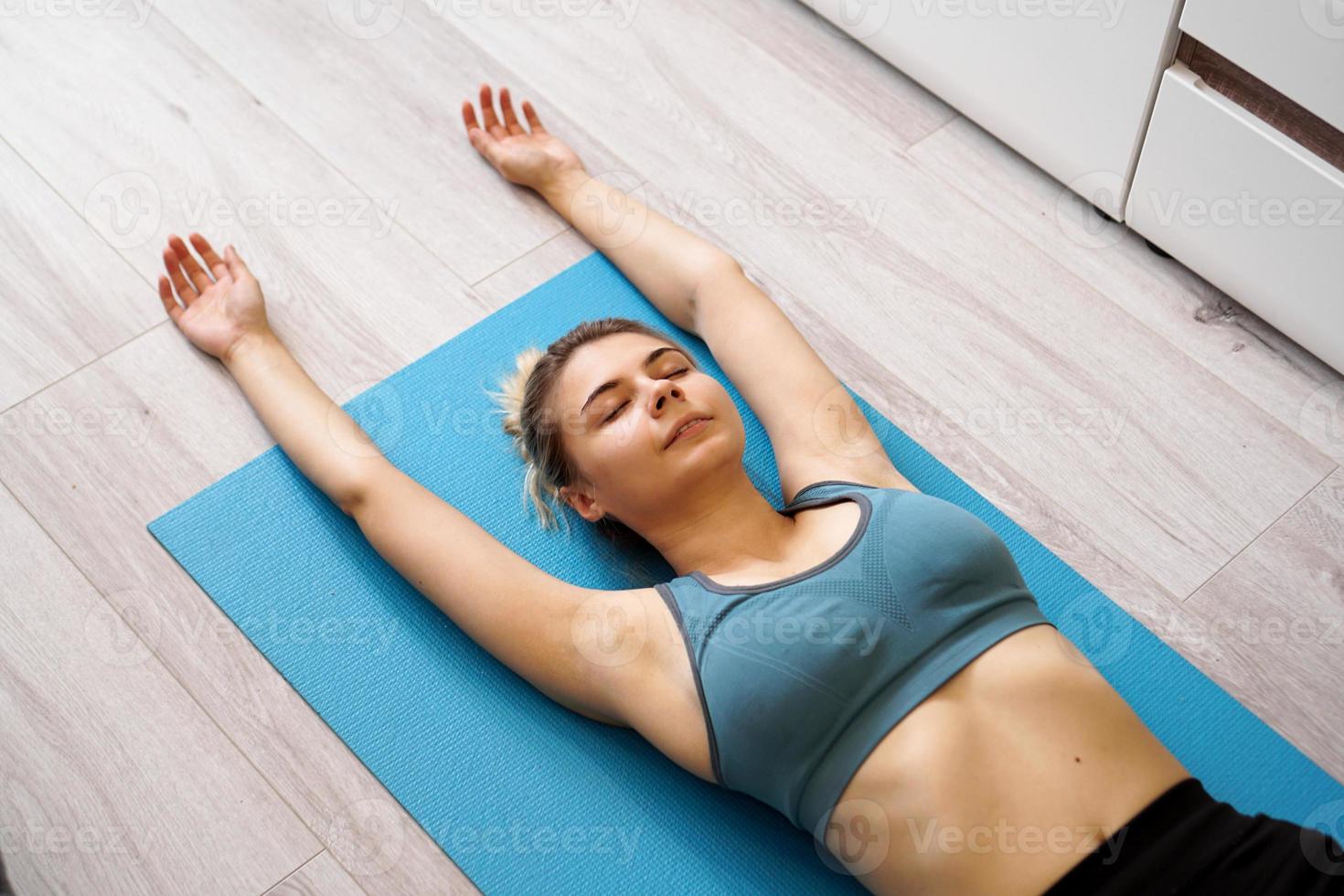 vista superior de uma bela jovem deitada no tapete de ioga após o treino foto