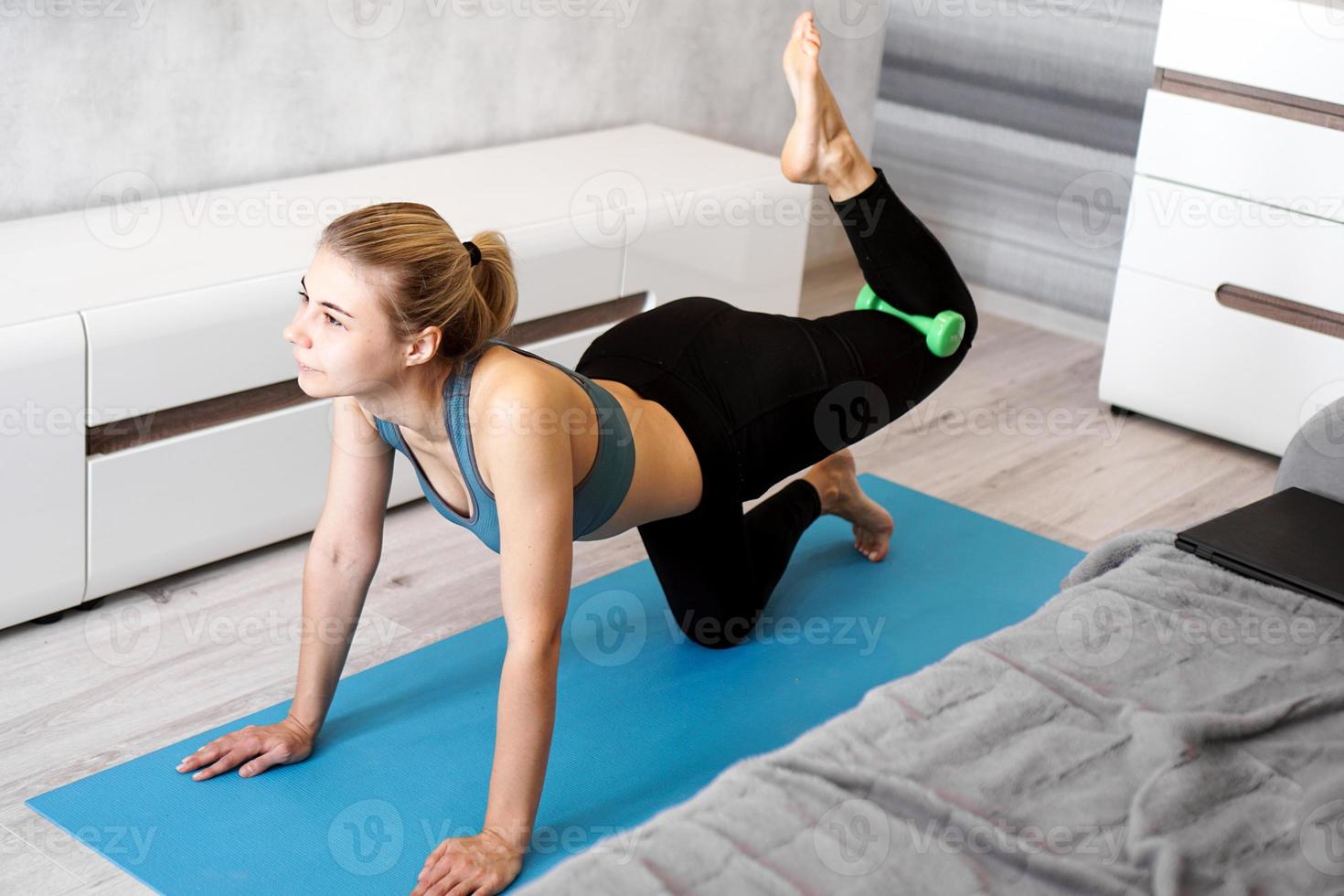 muito jovem treinador fazendo exercícios, usando halteres foto