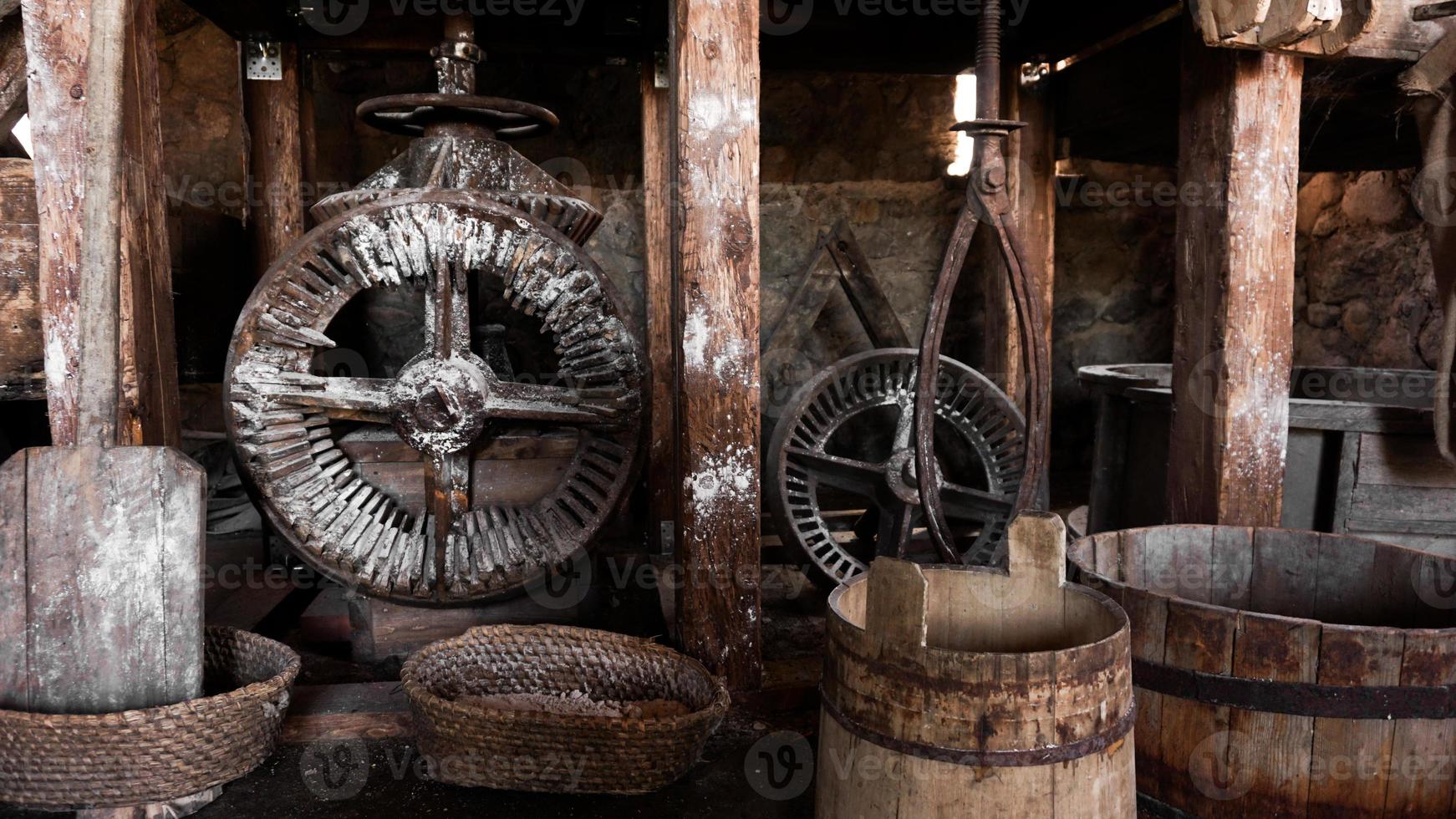 um antigo moinho manual feito de pedras e madeira. dispositivo de moagem de farinha foto