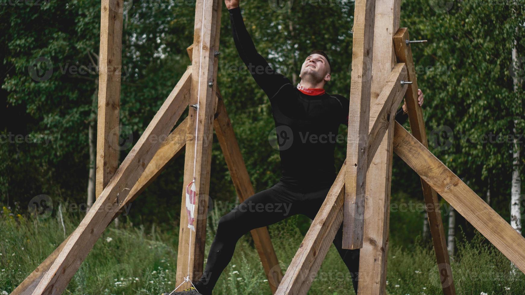 homem passando por obstáculos durante a pista de obstáculos no campo de treinamento foto