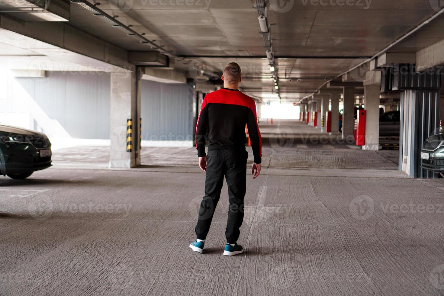 um jovem com um uniforme esportivo em um estacionamento subterrâneo. foto