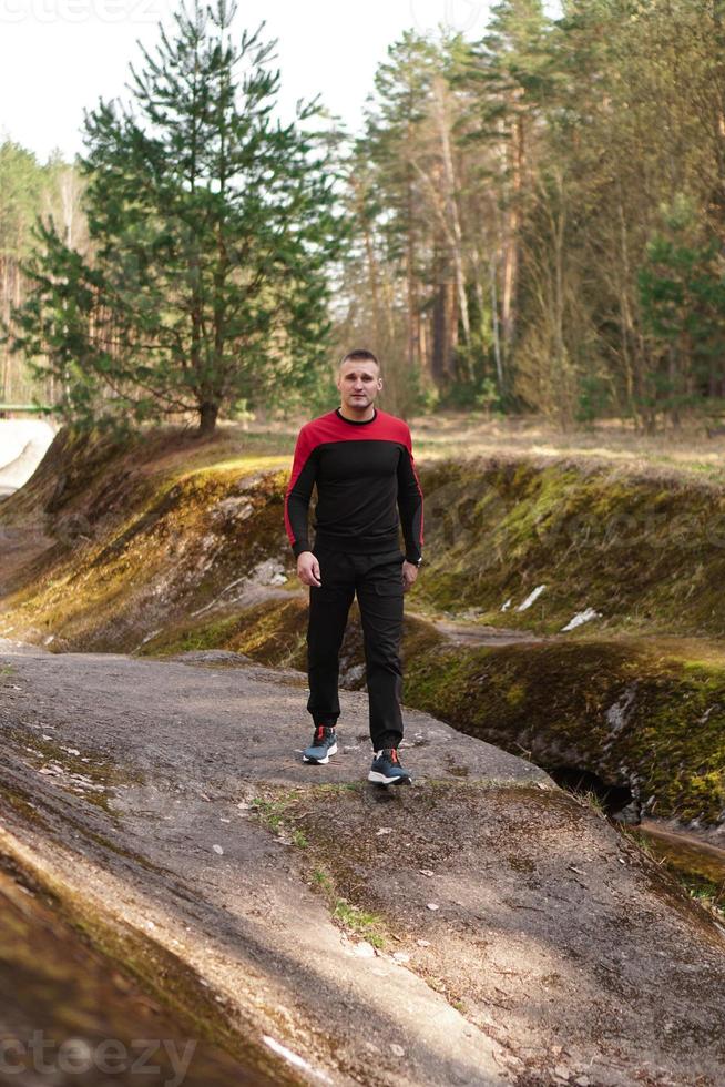 jovem atleta masculino correndo na floresta. homem correndo foto